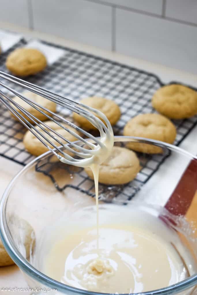 Maple icing dripping off a metal whisk