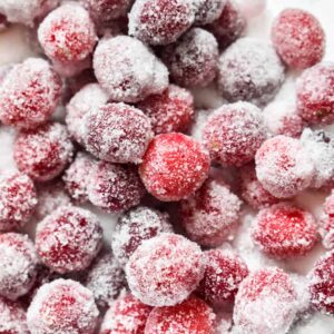 Vibrant red sugared cranberries in a bowl