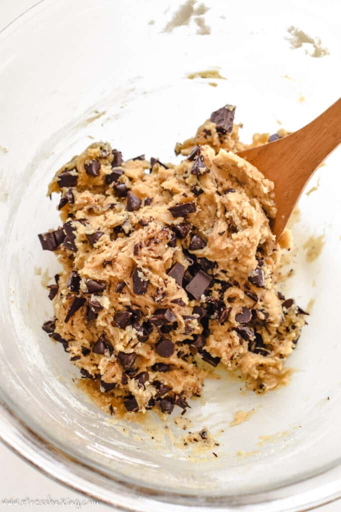 Chocolate chip cookie dough in a clear mixing bowl