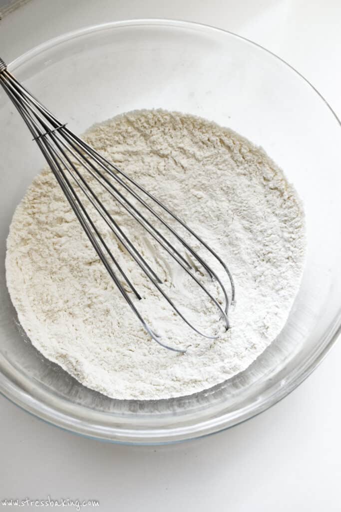 Dry ingredients being whisked in a clear bowl