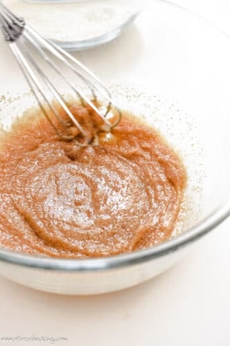 Wet ingredients being whisked in a clear bowl