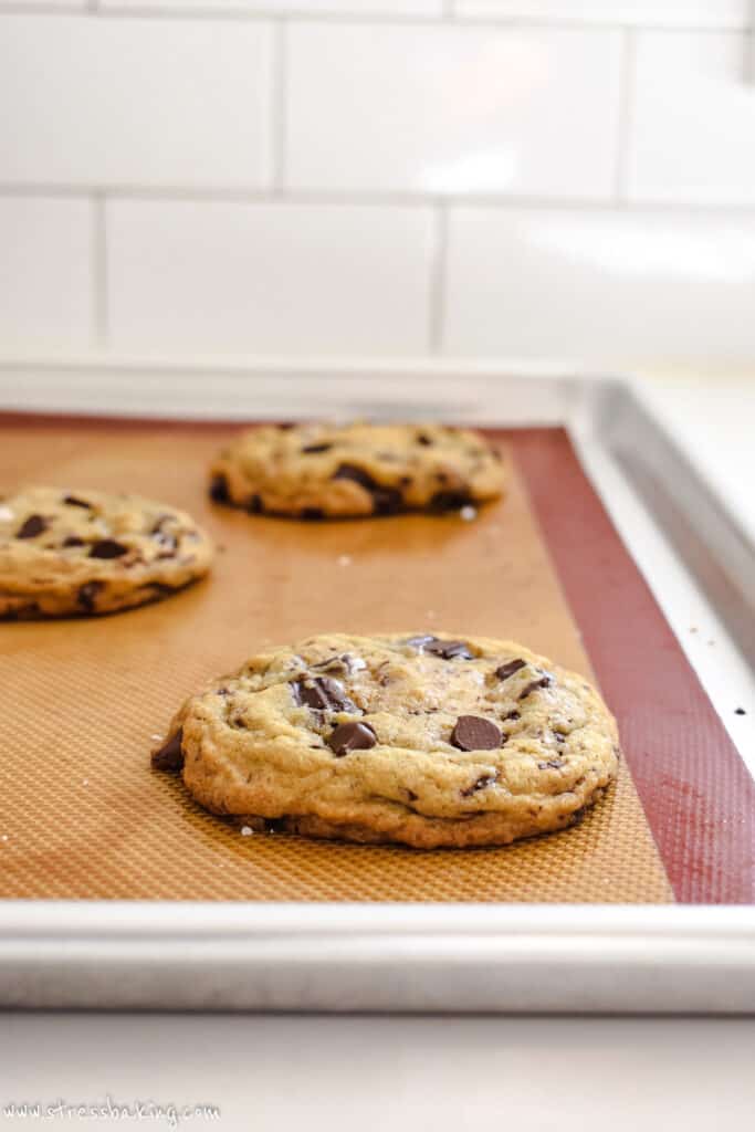 Chocolate chip cookies cooling on a baking sheet