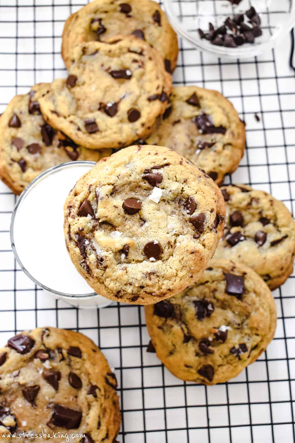 A chocolate chip cookie on top of a glass of milk