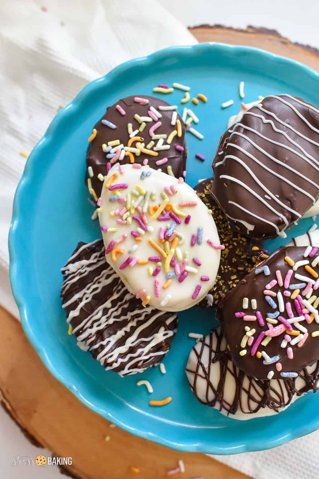 Homemade chocolate covered peanut butter eggs on a blue cake stand with sprinkles