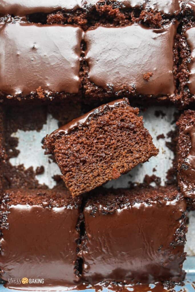 A slice of rich chocolate cake with chocolate icing on it's side