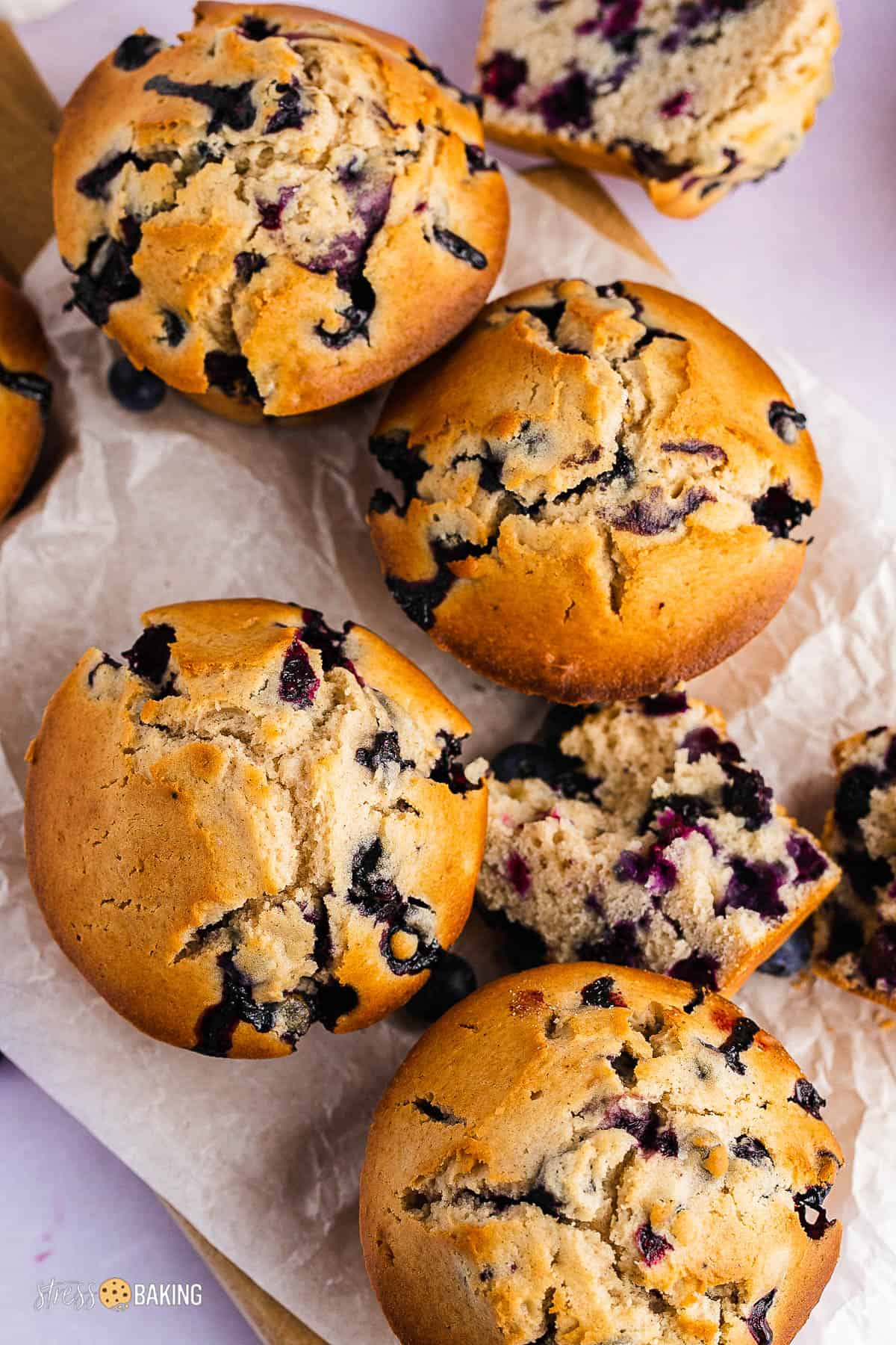 Big blueberry muffins with golden brown tops on parchment paper