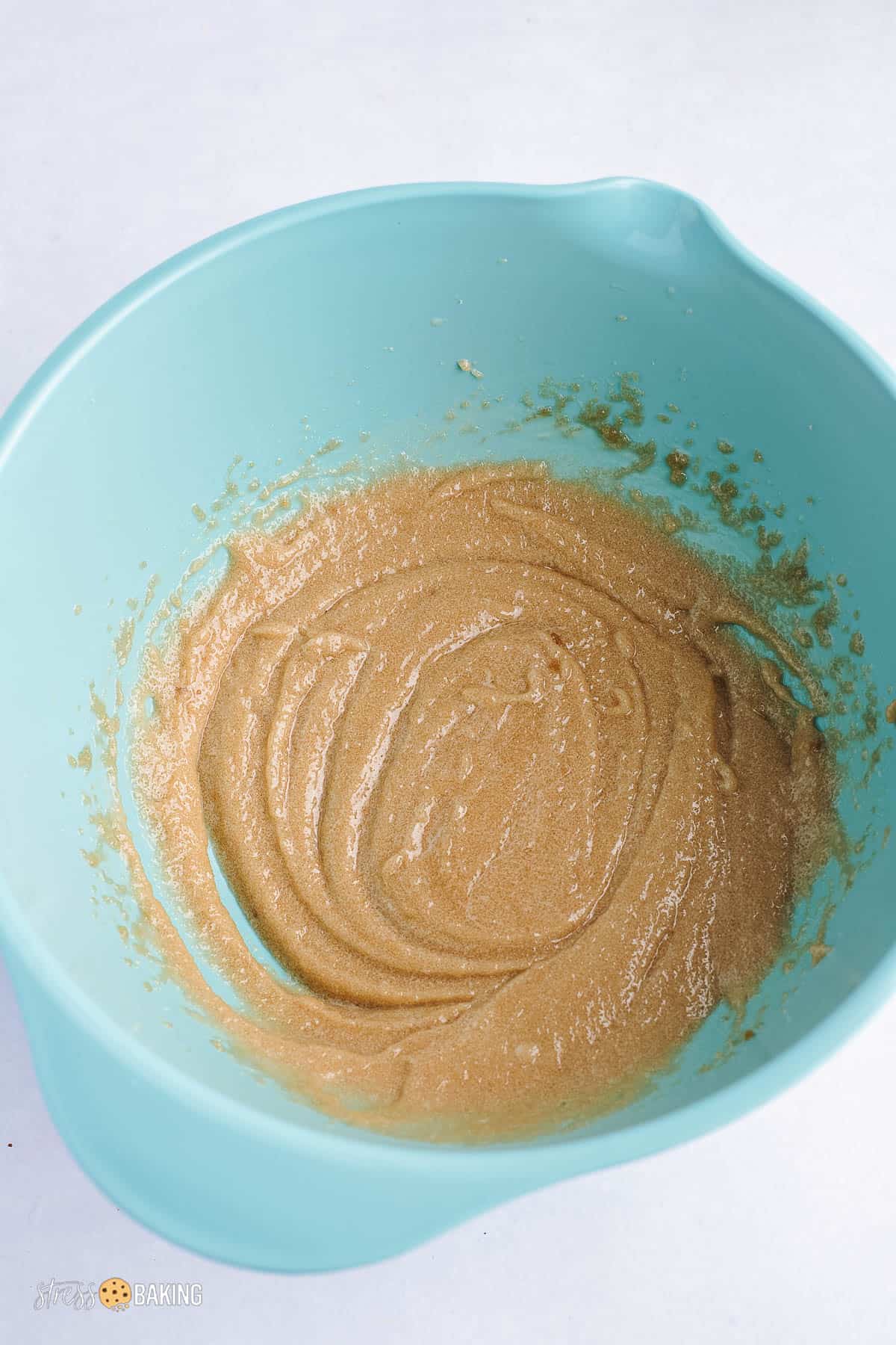 Tan wet batter mixture in a teal mixing bowl