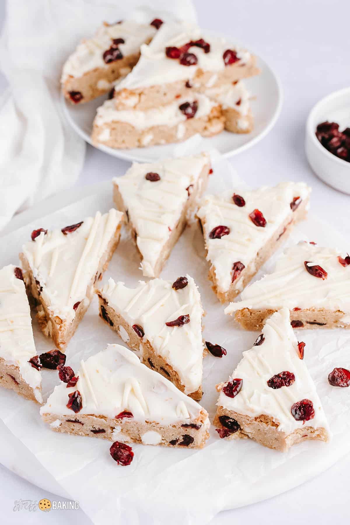 A bunch of triangle shaped cranberry bliss bars on a white counter