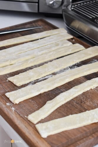 Puff pastry strips on a cutting board