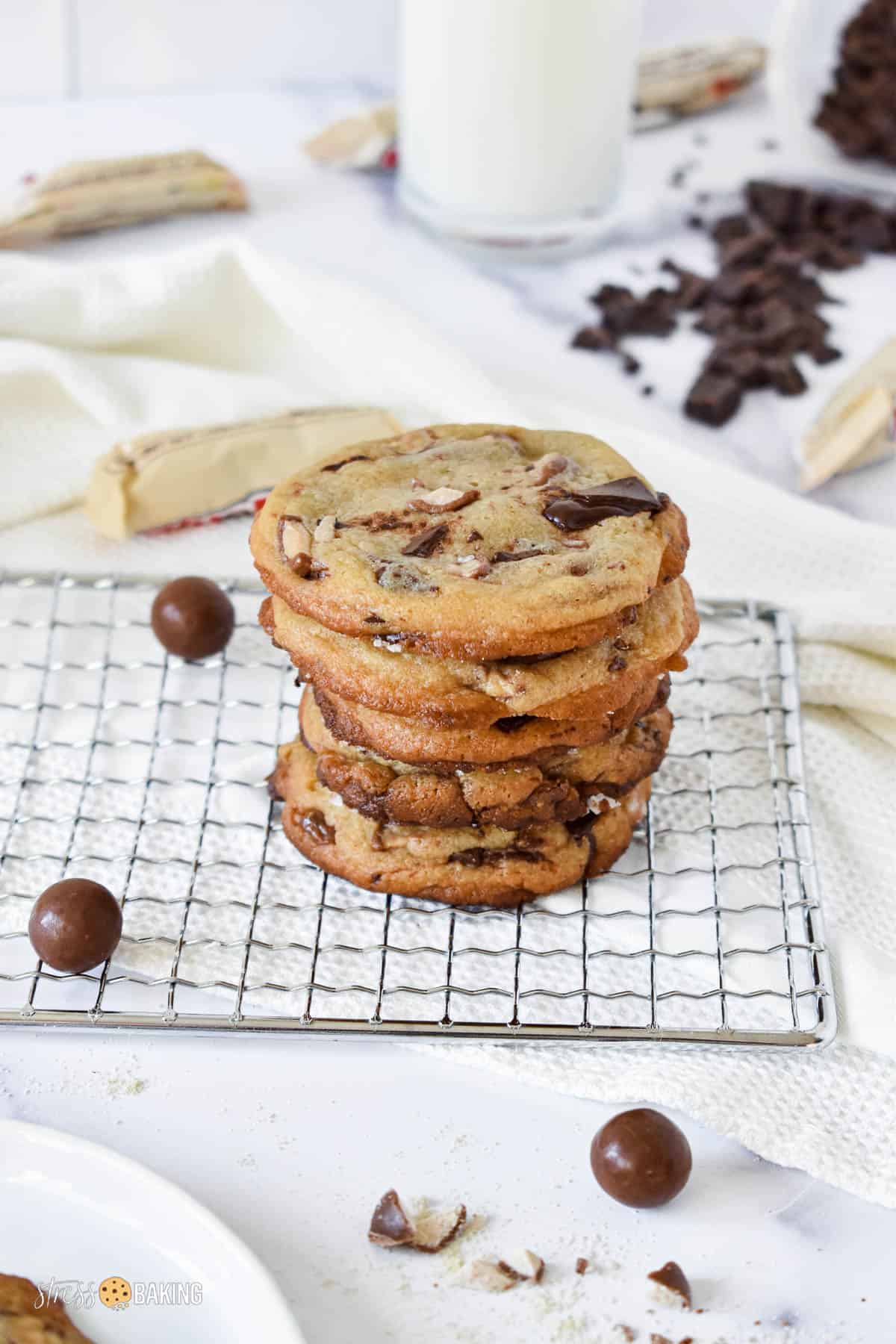 Short stack of malted chocolate chip cookies on a wire rack