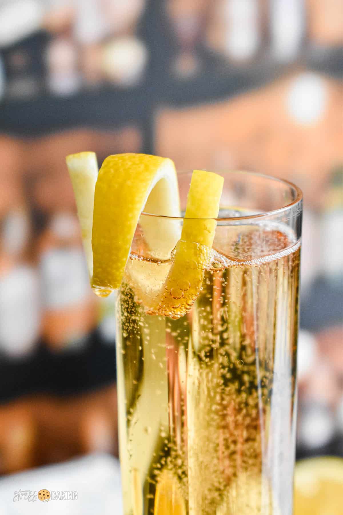 A lemon twist garnish on the edge of a champagne flute