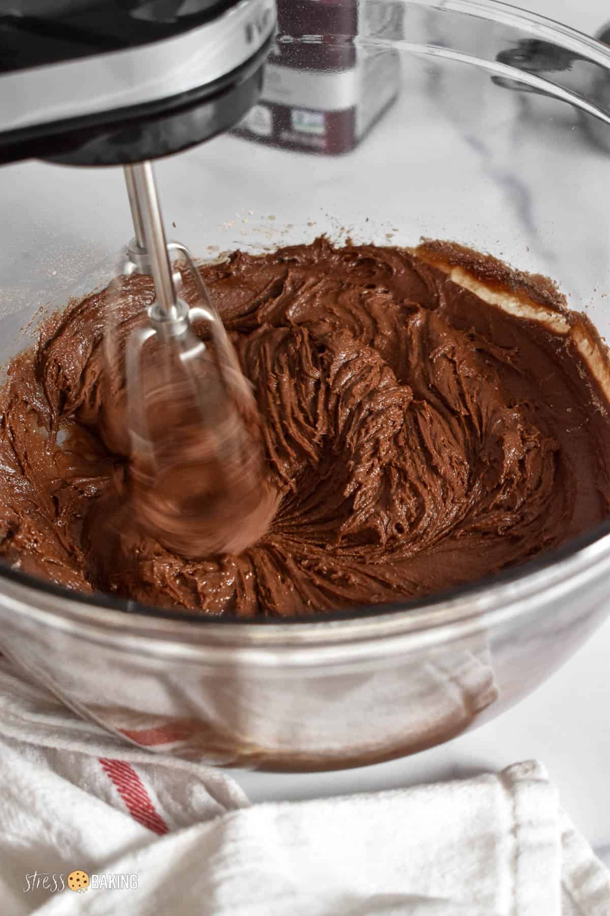 Chocolate cookie dough being mixed with a hand mixer