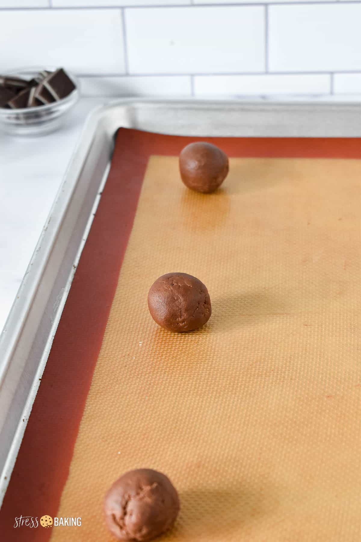 Chocolate cookie dough balls on a baking sheet
