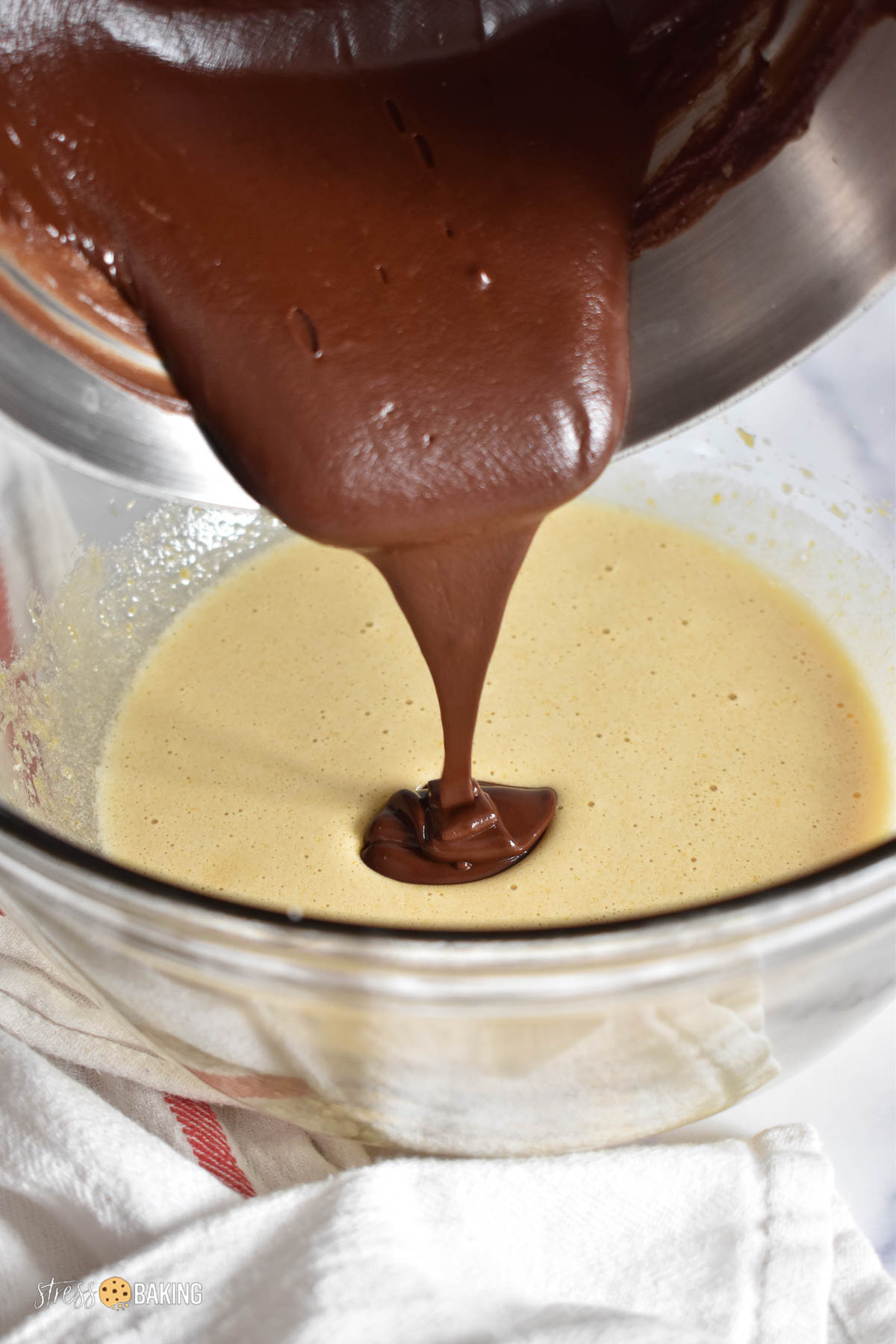 Melted chocolate being poured into yellow batter
