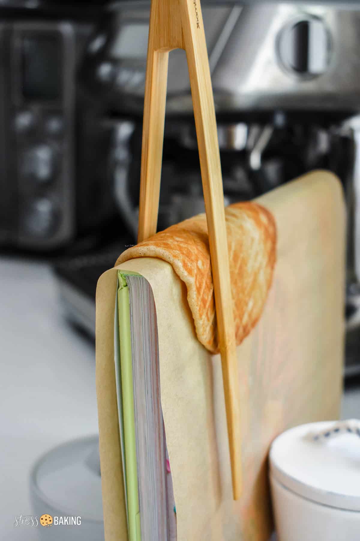 A waffle cone propped on a book binding to form a taco shape