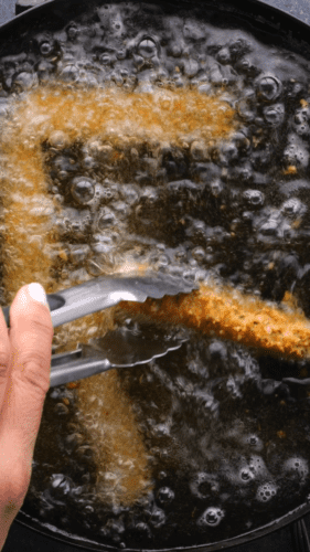Mozzarella sticks being fried in oil