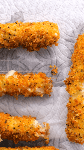 Golden mozzarella sticks on a paper towel to soak up the excess oil
