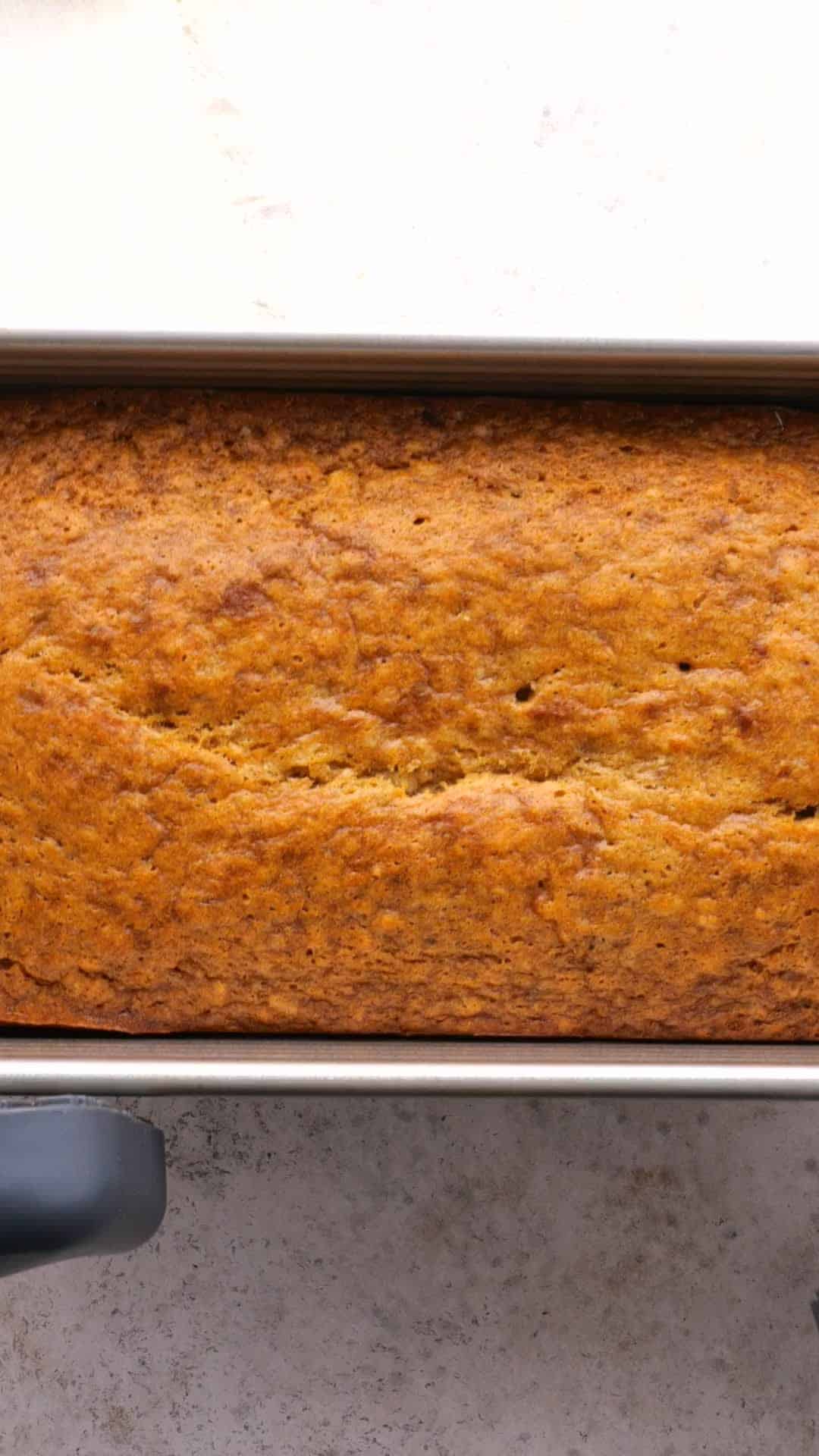 Golden brown banana bread in a loaf pan