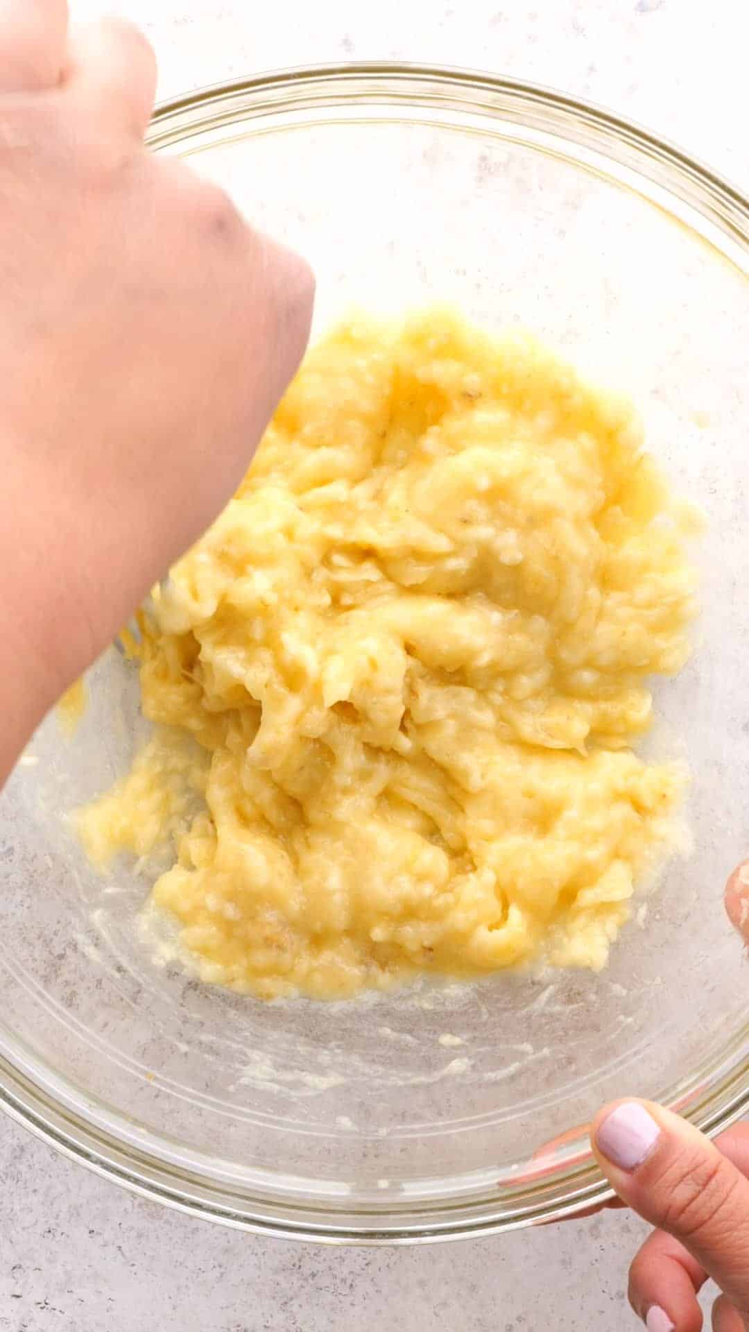 Bananas mashed in a clear mixing bowl