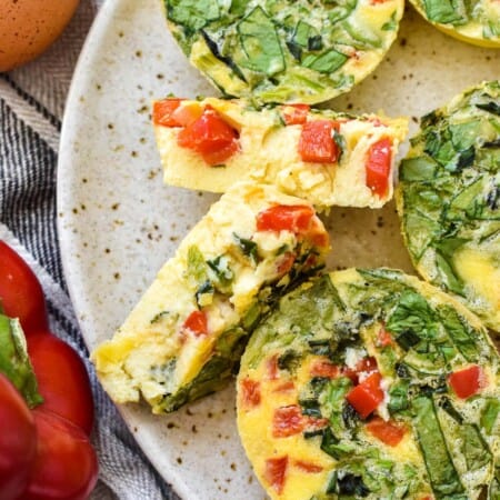 Yellow egg bites full of spinach and diced bell pepper