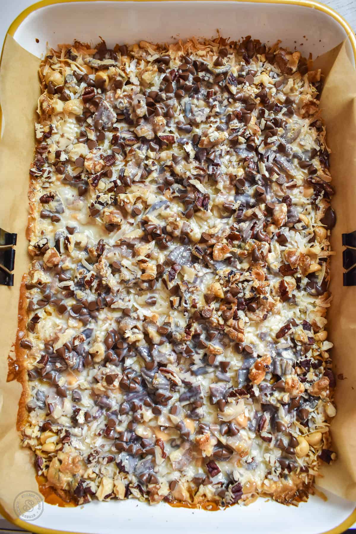Magic cookie bars fresh out of the oven with melted chocolate and toasted nuts on top
