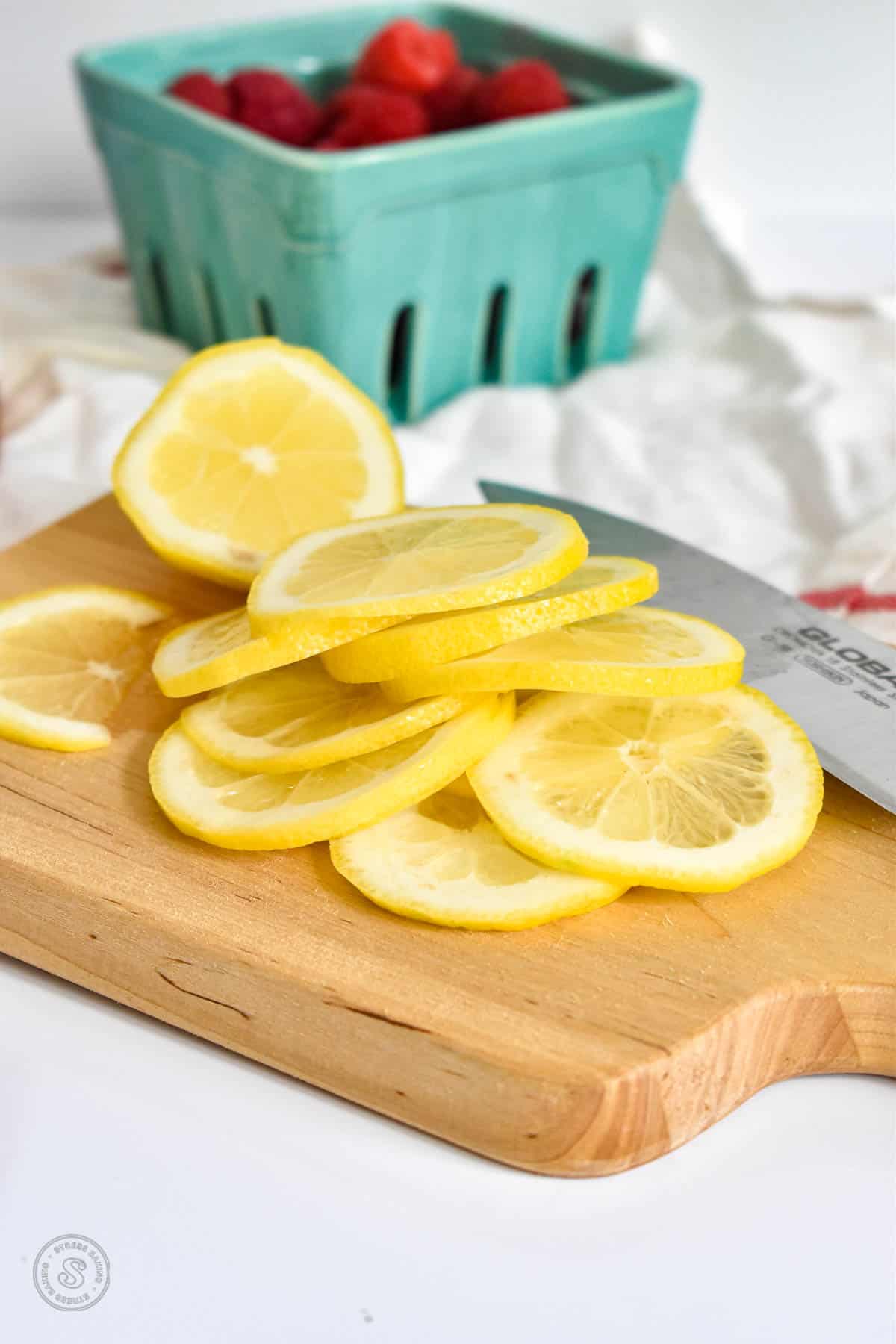 Thin slices of lemon on a small wooden cutting board