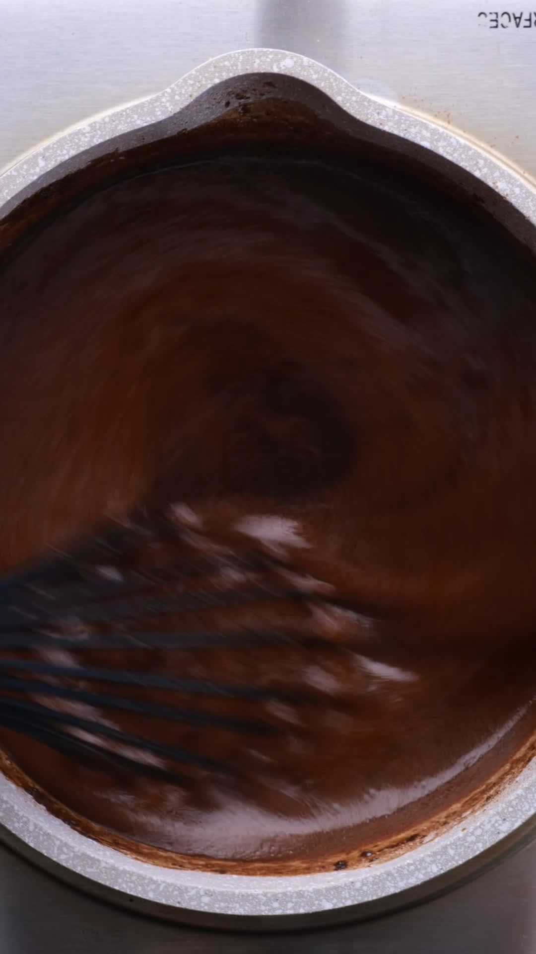 Chocolate mixture being whisked in a mixing bowl
