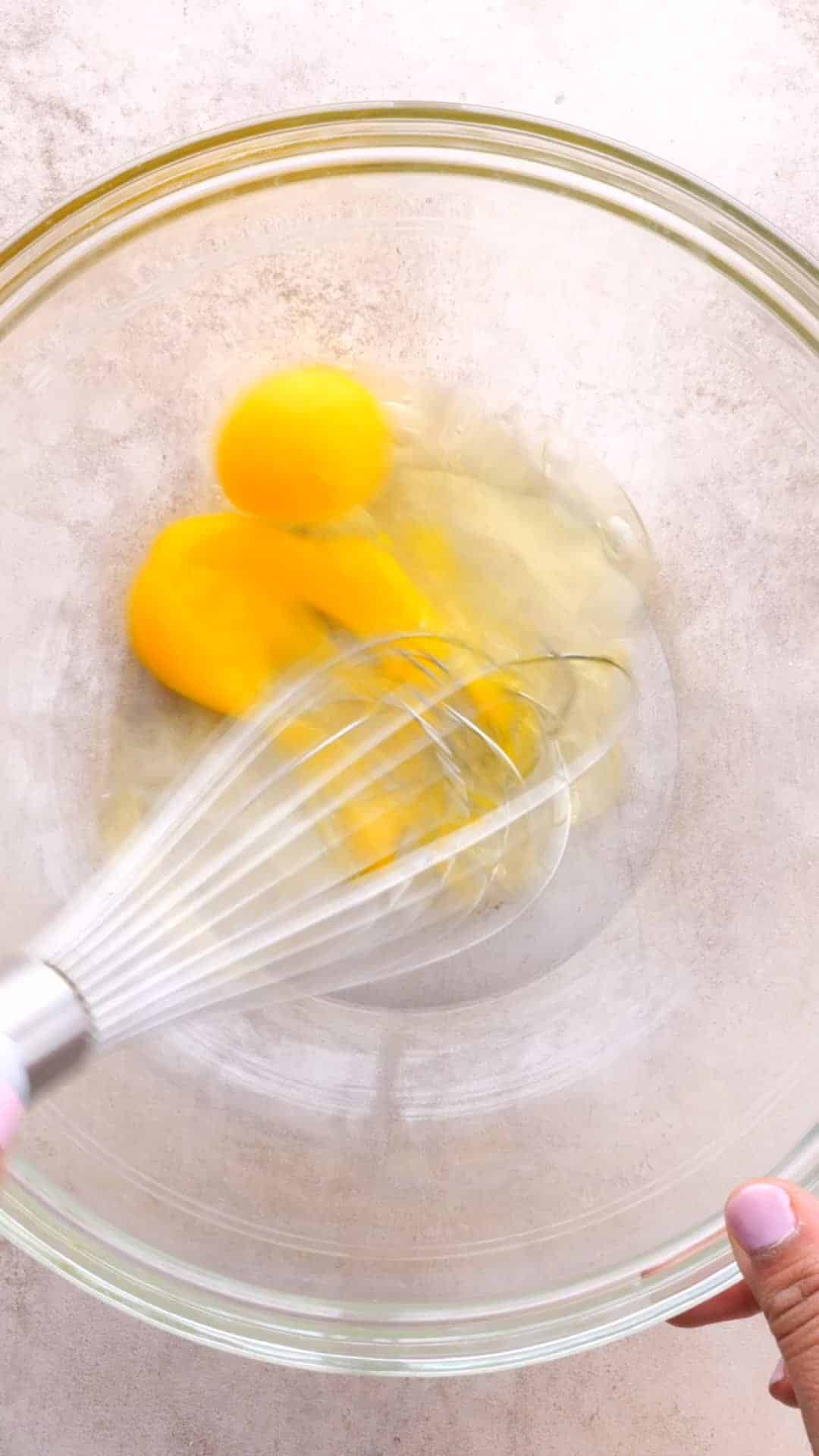 Whisking eggs in a clear mixing bowl
